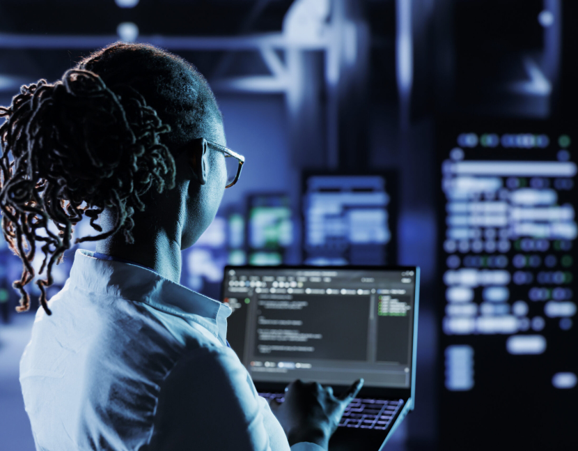 Computer scientist running code and programming on laptop, troubleshooting and upgrading high tech facility designed to accommodate multiple clusters of fully operational server rigs